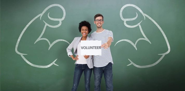 Portrait of a happy couple holding a volunteer note against green chalkboard