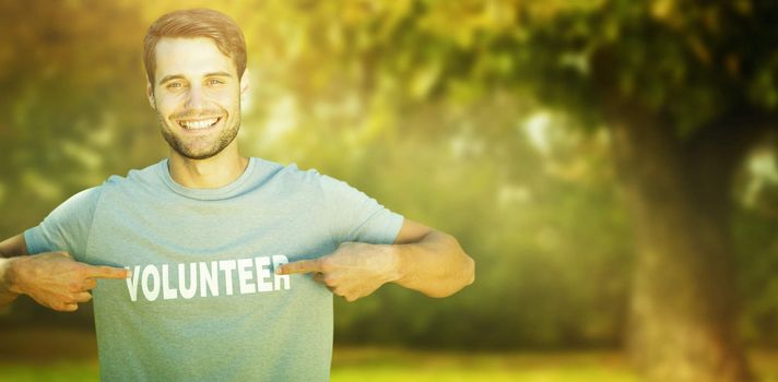 Happy volunteer in the park against trees and meadow in the park