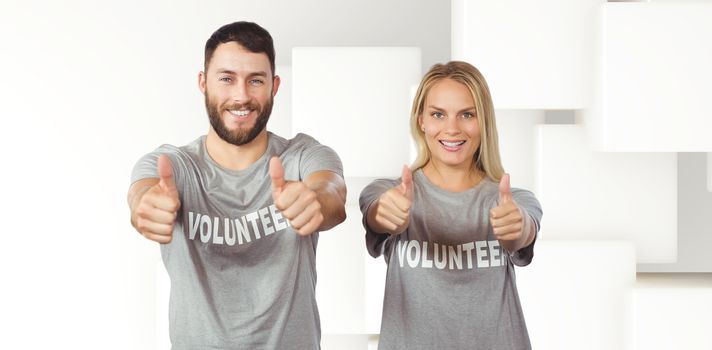Smiling volunteers giving thumbs up  against abstract white design