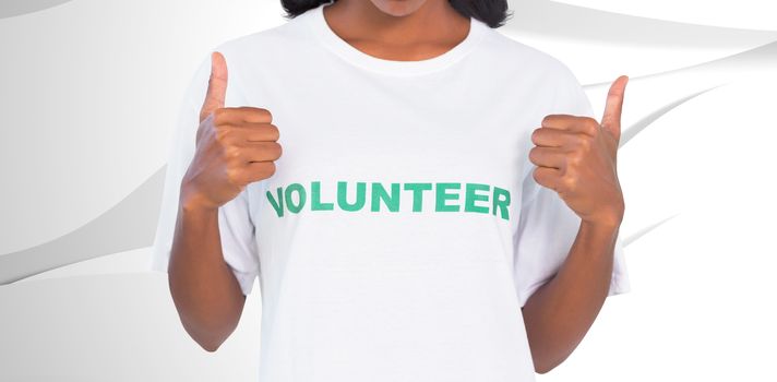 Woman wearing volunteer tshirt and giving thumbs up against white wave design