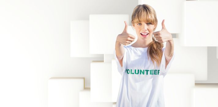Natural blonde wearing a volunteering t shirt giving thumbs up against abstract white design