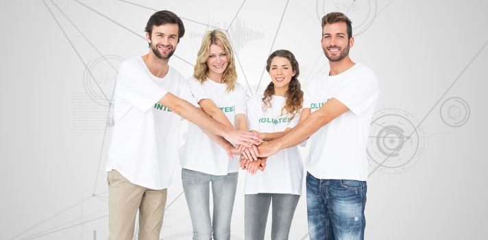 Group portrait of happy volunteers with hands together against interface with graphs