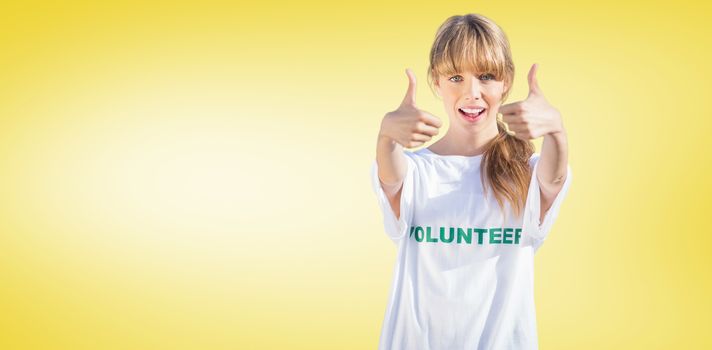 Natural blonde wearing a volunteering t shirt giving thumbs up against yellow vignette