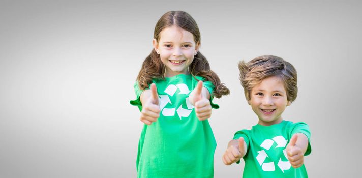 Happy siblings in green with thumbs up  against grey vignette