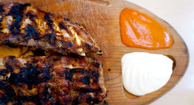 spare ribs in wooden tray with sauce