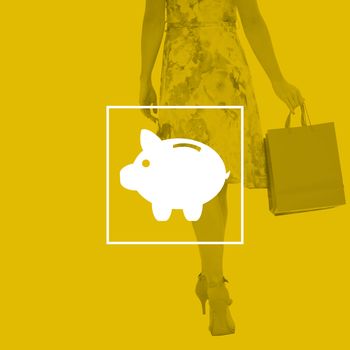 Elegant woman with shopping bags against piggy bank