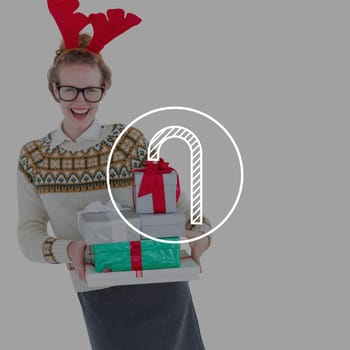 Happy geeky hipster holding presents  against candy cane