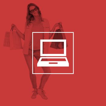 Woman holding some shopping bags against laptop