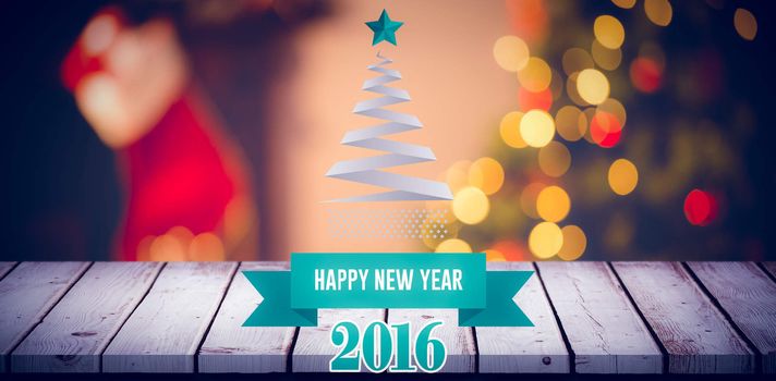 New year graphic against desk with christmas tree in background
