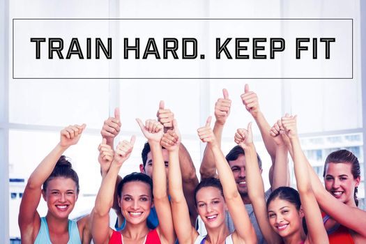Motivational new years message against fit people gesturing thumbs up in exercise room