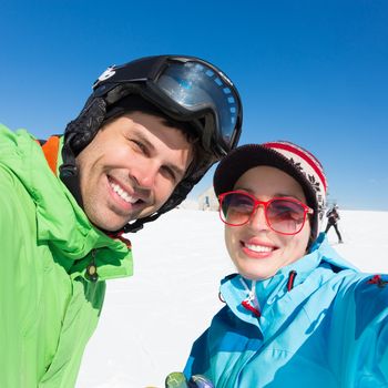 Selfie of couple skiers on winter vacations in the Alp mountains, Triglav natural park, Vogel, Slovenia.