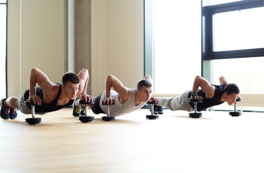 sport, fitness, lifestyle and people concept - group of men with dumbbells in gym