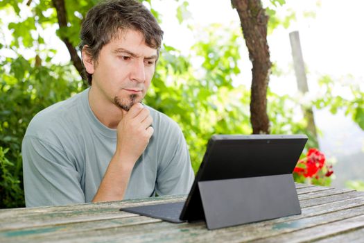 casual man working with a tablet pc, outdoor