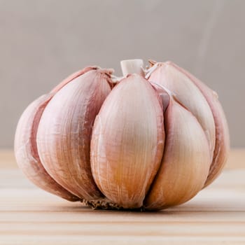 Close Up organic garlic with selective focus on the teak wood background