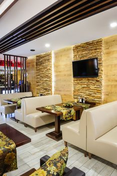 Modern restaurant interior with tables and sofas