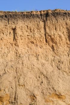 Cut of soil with many layers visible and grass on top