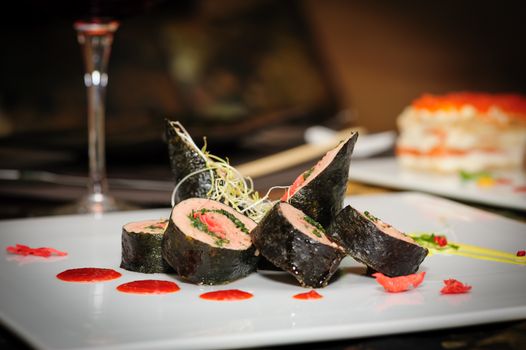 Sushi rolls with salmon and seaweed served on plate