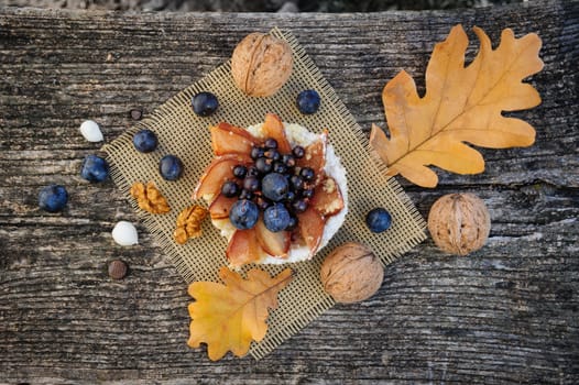 Romantic autumn still life with basket cake, walnuts, blackthorn berries and leaves, top view