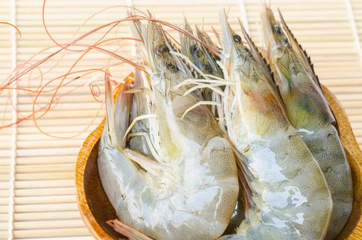 close up raw shrimps in cup on the wood background.