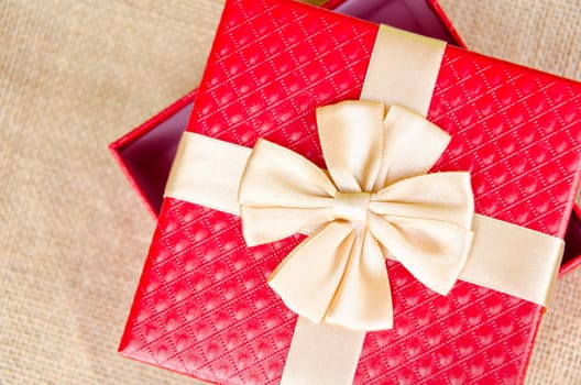 gift box with gold ribbon on sack background