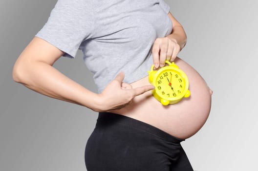 Pregnant woman's belly with clock.