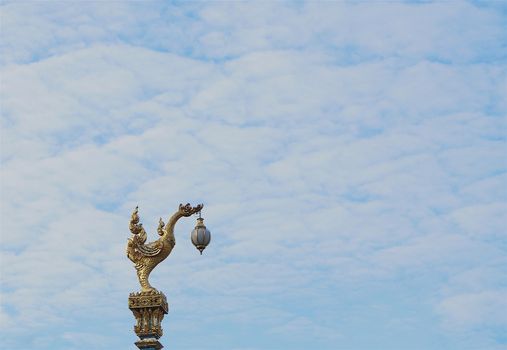 Thai traditional street lamp, beautiful golden swan on blue sky background.