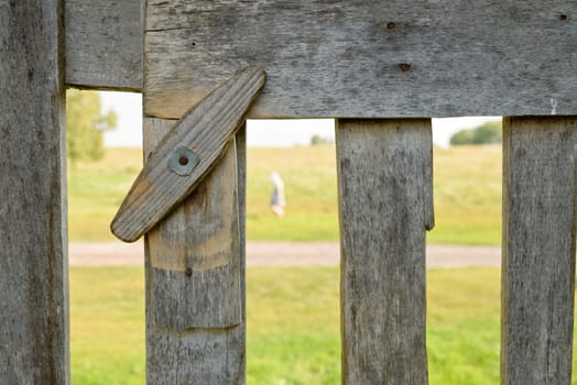Traditional revolving wooden latch and a fragment of a fence