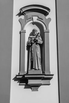 St. Fracis statue on the facade of the Church of the Exaltation of the Holy Cross of the Friars Minor in Cieszyn, Poland, built in late Baroque architectural style.