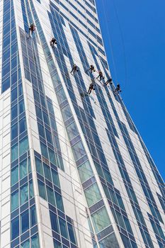 Special service team cleans the facade of the Orco Tower in Warsaw, building designed by Daniel Libeskind, famous architect who also created the tower in place of WTC in NY.