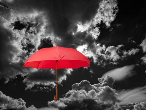 red umbrella against stormy clouds