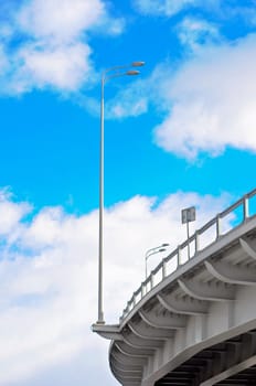 lamppost at the overpass on background of blue sky with clouds