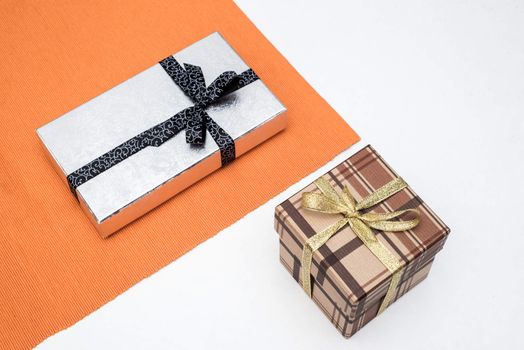 brown and silver gift box with bow on white background