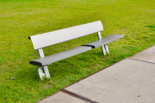 Modern bench in a green grassy lawn