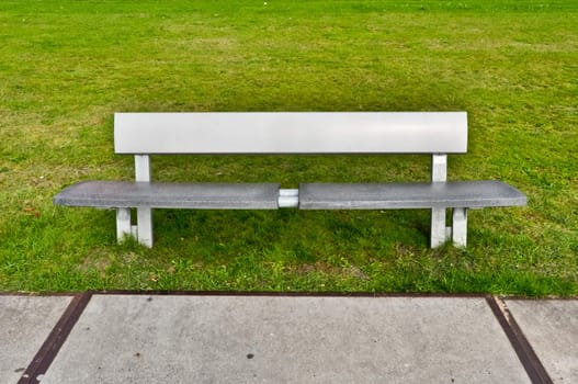 Modern bench in a green grassy lawn