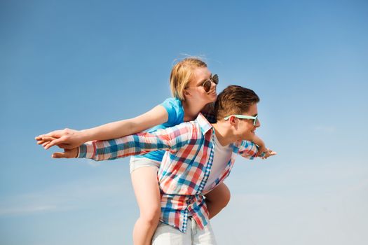 holidays, vacation, love and friendship concept - smiling couple having fun outdoors