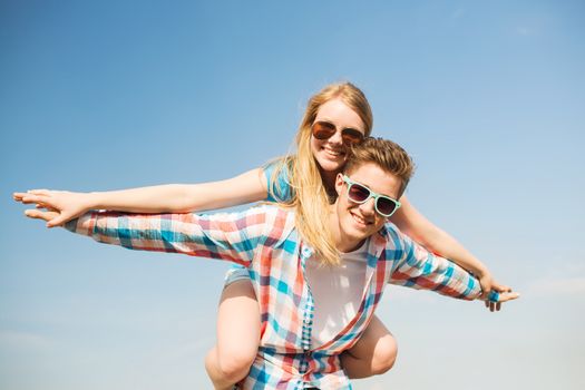 holidays, vacation, love and friendship concept - smiling couple having fun outdoors