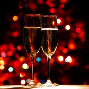 Two champagne glasses on color bokeh background