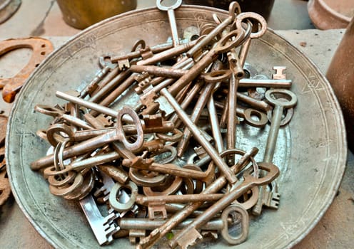 a lot of old brass key on an old plate