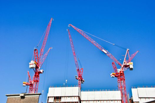 red construction  cranes on blue sky background