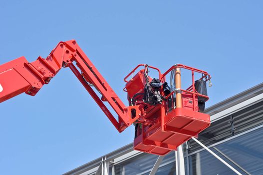 red hydraulic construction cradle against the blue sky