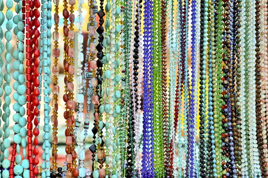 lots of colorful glass and stone beads hanging in a row