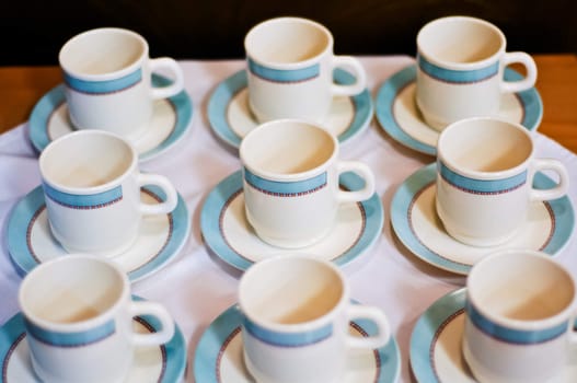 nine white porcelain tea cups and saucers and napkins