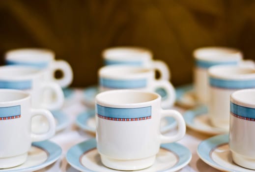 nine white porcelain tea cups and saucers and napkins