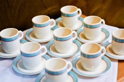 nine white porcelain tea cups and saucers and napkins