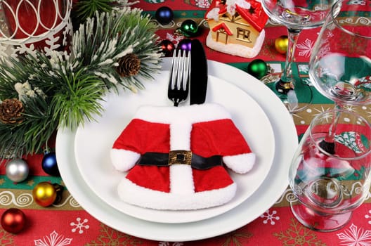 Fragment of the Christmas table serving coat of Santa Claus with cutlery
