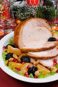 sliced baked turkey ham with fruit garnish on the Christmas table