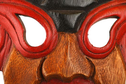 Asian traditional wooden mask with face of human or demon painted with vivid red and blue close up