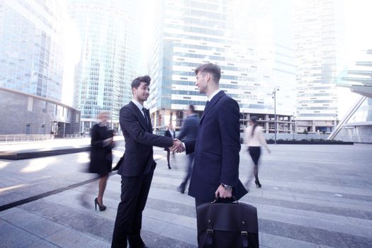 Business people shaking hands, finishing up a meeting outside office