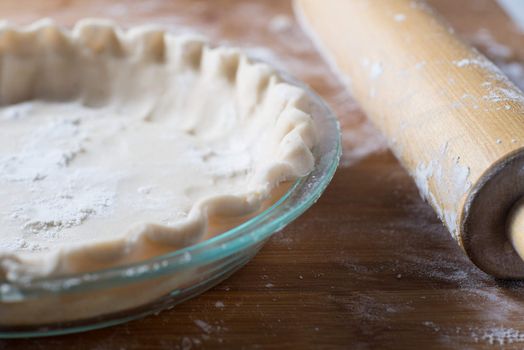 Fresh rolled pie crust in a pie plate baking