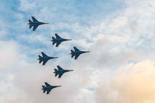 Silhouettes of russian fighter aircrafts SU-27 in the cloudy sky